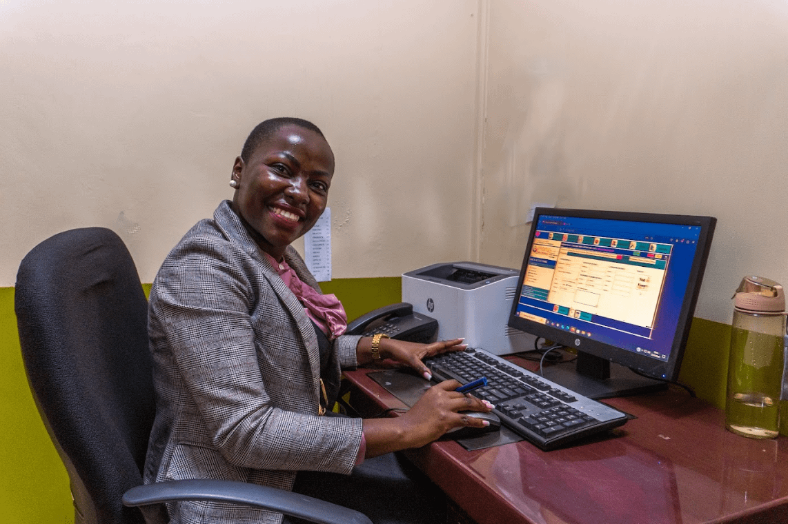 a woman sitting at a desk with a computer
